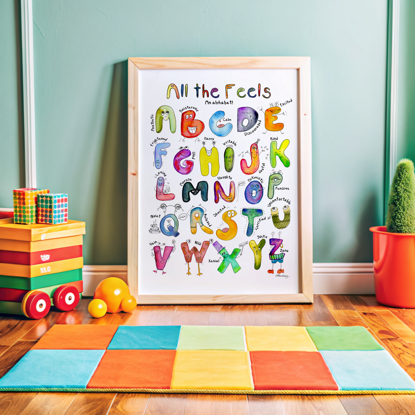 Framed children's poster with colorful alphabet letters on a wooden floor with toys and a plant.