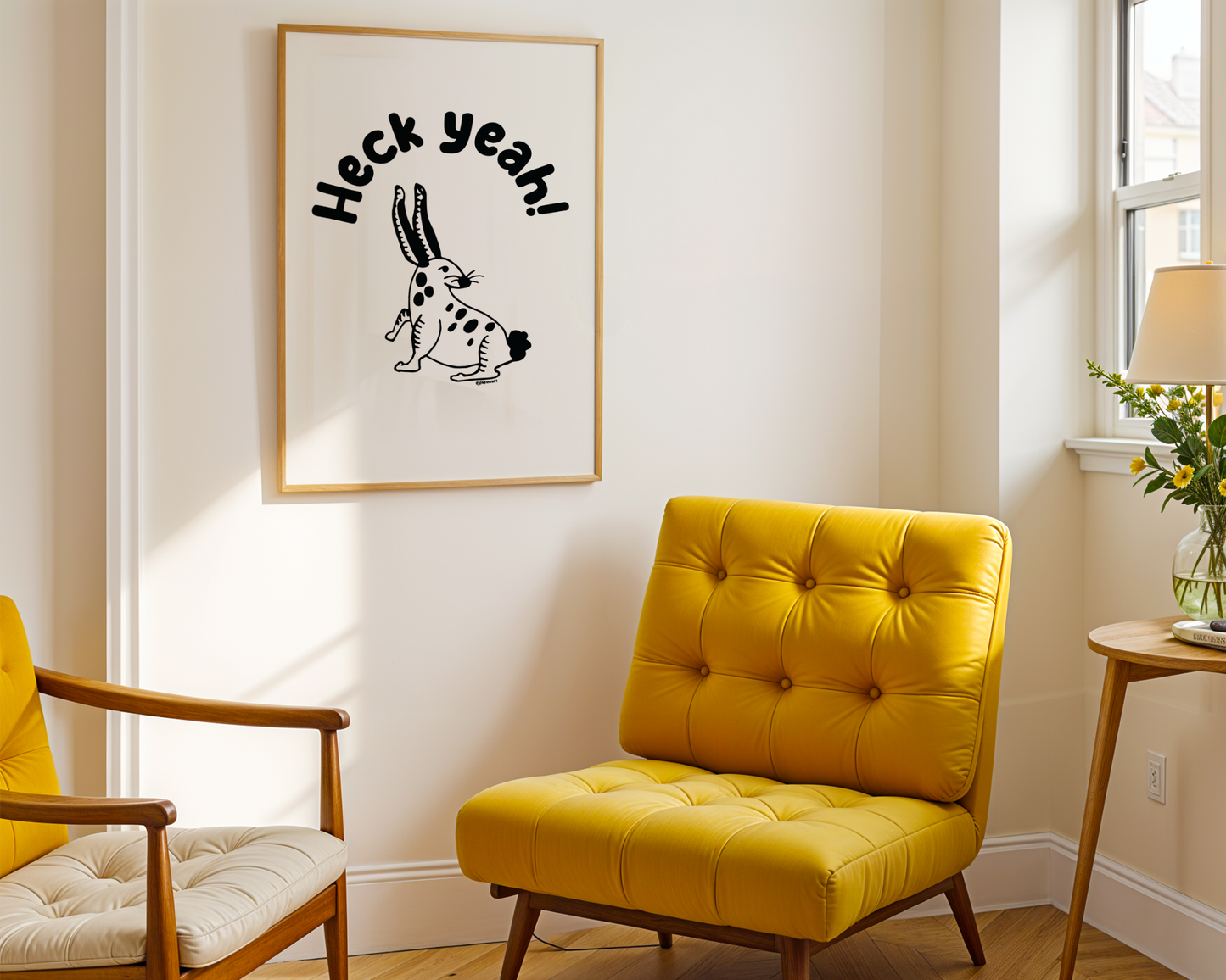 Room with modern yellow chair showing a framed print on the wall with handwritten bubble letters spelling out “Heck Yeah!” Illustrated rabbit character in black on a white background with clean lines. Inspired by the southwest and western United States.