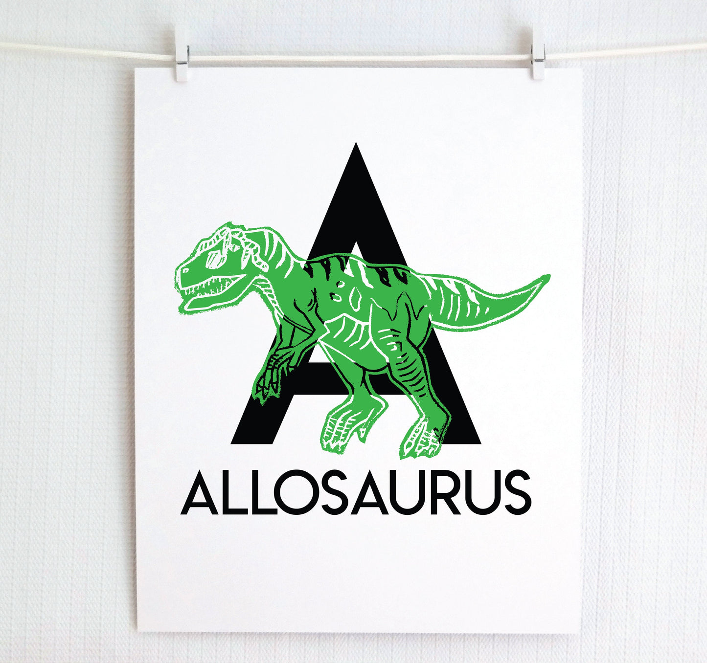 Bold modern letter A in black with “Allosaurus” printed below. Printed dinosaur in color appears over the letter to created an alphabet art print.