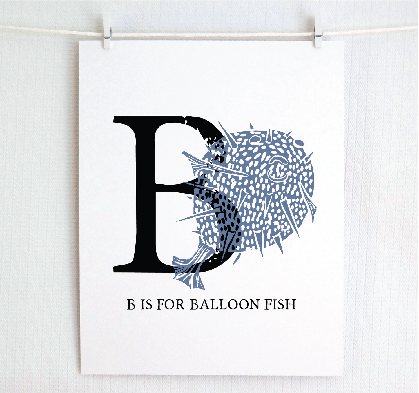 An illustrated balloon fish with done in printmaking style over decorative style block lettering text “B” with “B is for Balloon Fish” text printed below.