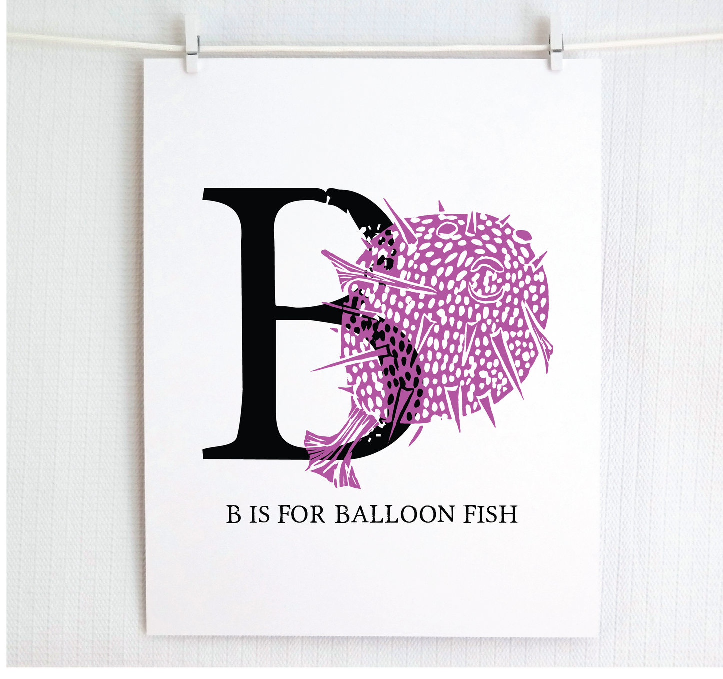 An illustrated balloon fish with done in printmaking style over decorative style block lettering text “B” with “B is for Balloon Fish” text printed below.