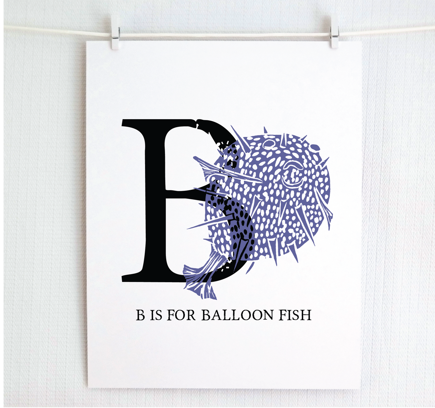 An illustrated balloon fish with done in printmaking style over decorative style block lettering text “B” with “B is for Balloon Fish” text printed below.