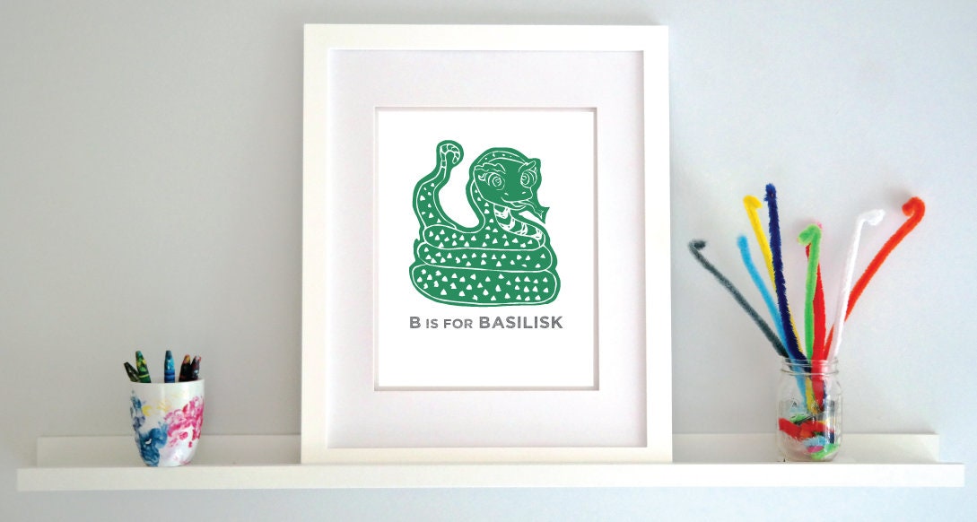 Friendly illustrated basilisk giving a slithery smile above “B is for Basilisk” text in a gray block font below.