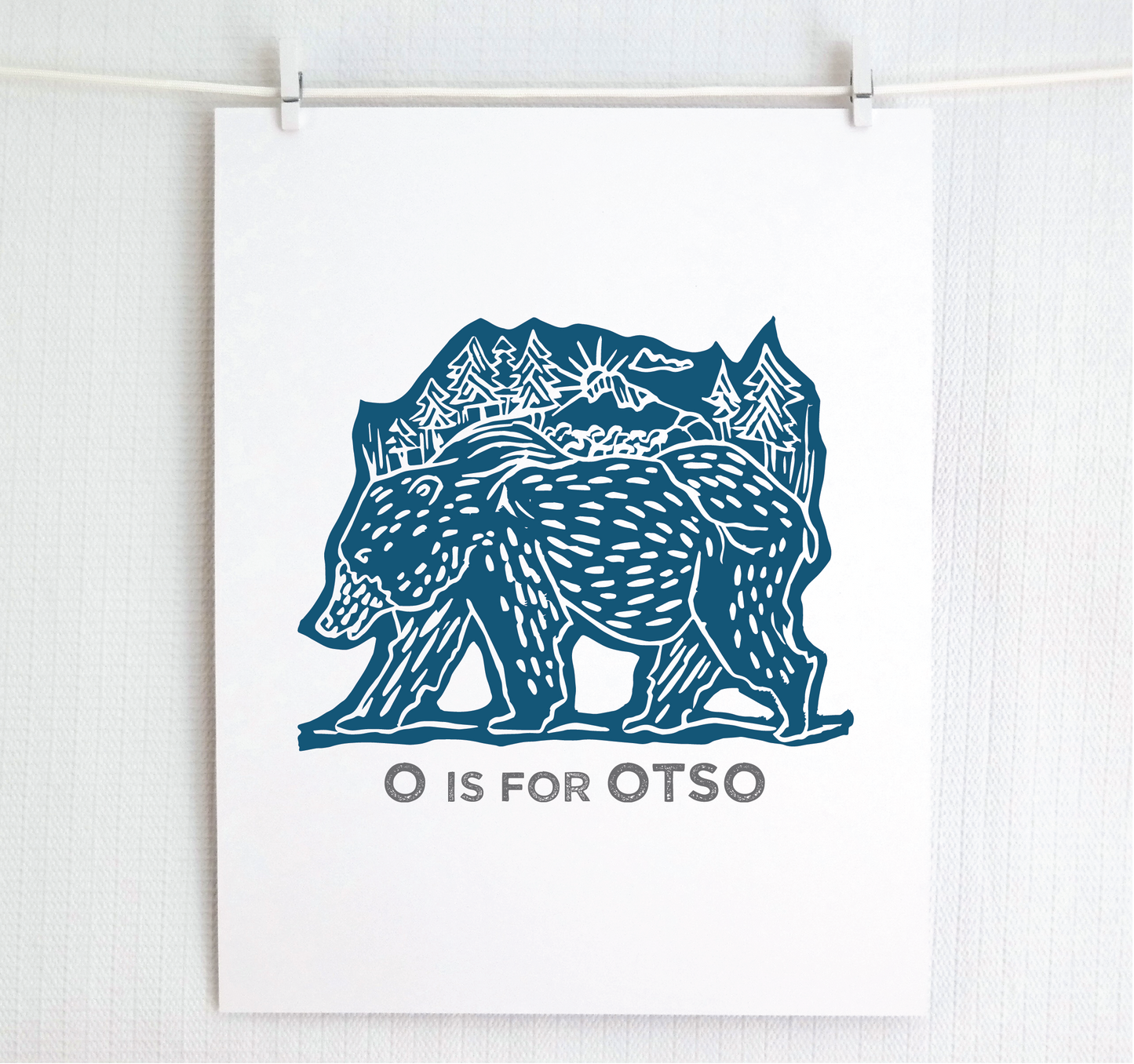 Friendly illustrated bear walking with the forest growing on his back. “O is for Otso” text in a gray block font below.