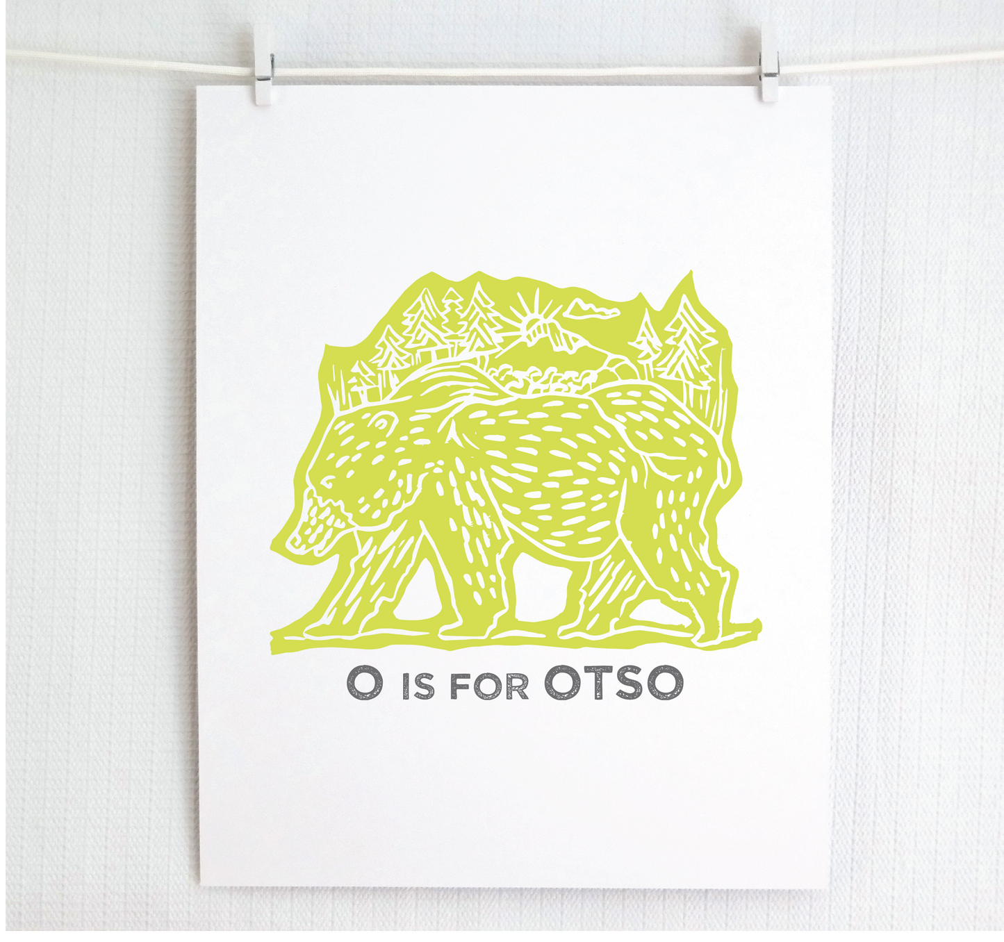 Friendly illustrated bear walking with the forest growing on his back. “O is for Otso” text in a gray block font below.