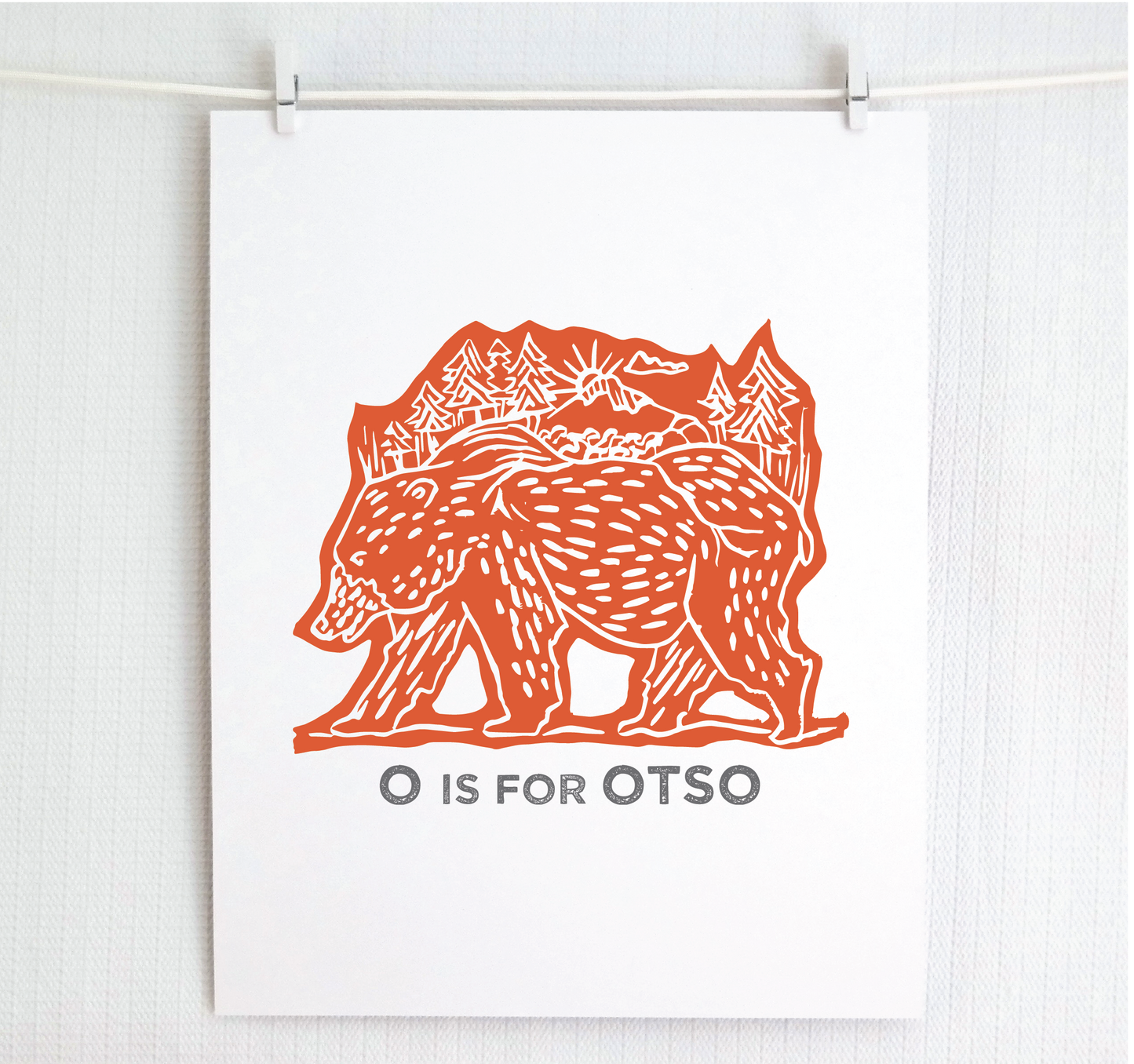 Friendly illustrated bear walking with the forest growing on his back. “O is for Otso” text in a gray block font below.