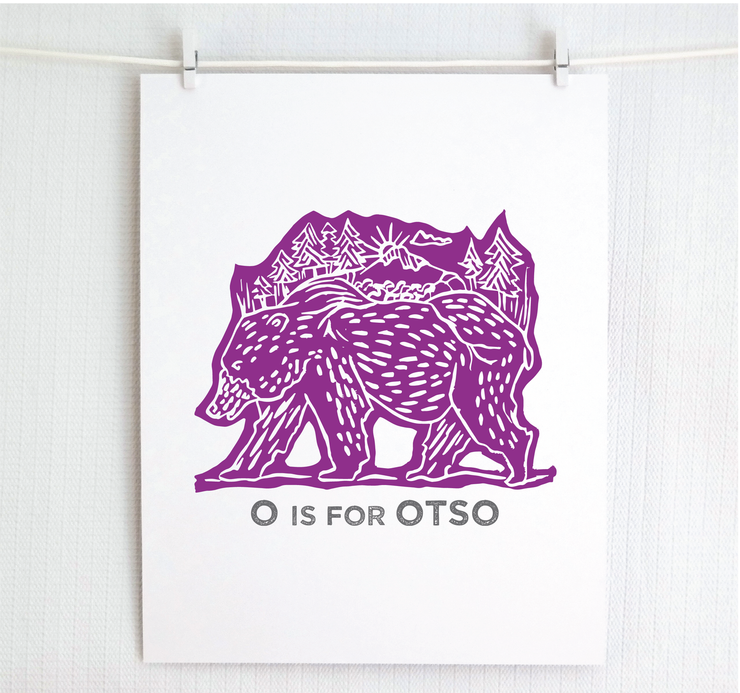 Friendly illustrated bear walking with the forest growing on his back. “O is for Otso” text in a gray block font below.