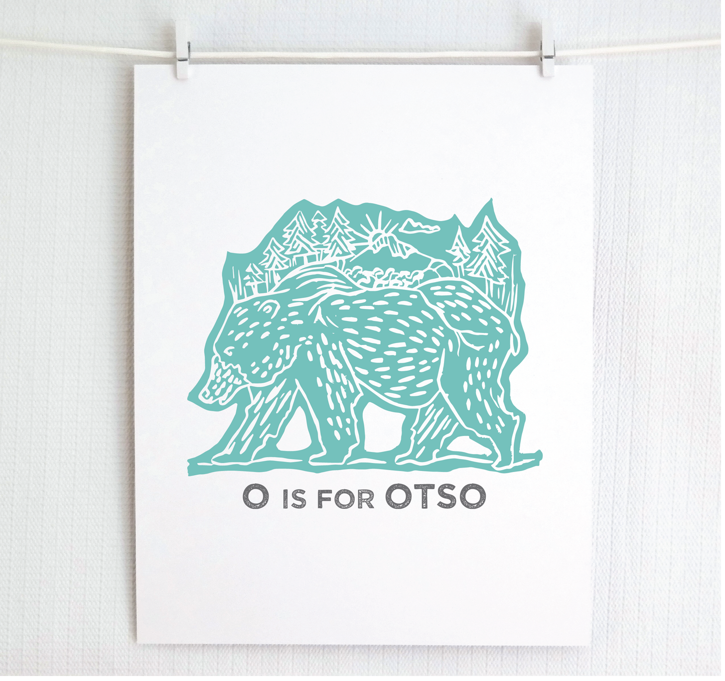Friendly illustrated bear walking with the forest growing on his back. “O is for Otso” text in a gray block font below.