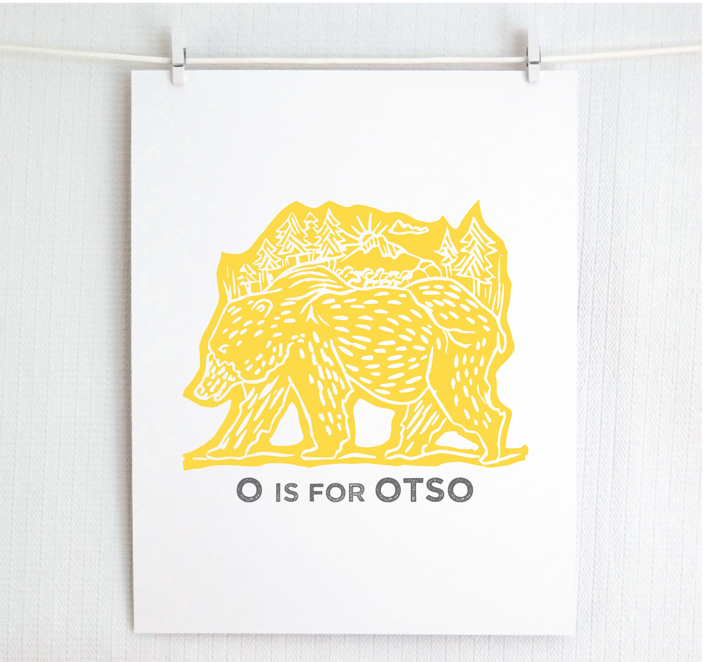 Friendly illustrated bear walking with the forest growing on his back. “O is for Otso” text in a gray block font below.