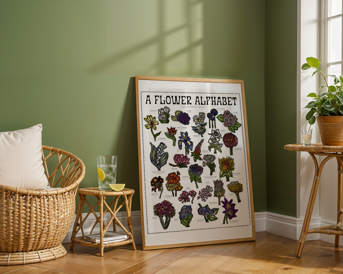 Framed artwork titled 'A Flower Alphabet' in a room with green walls and wooden furniture.