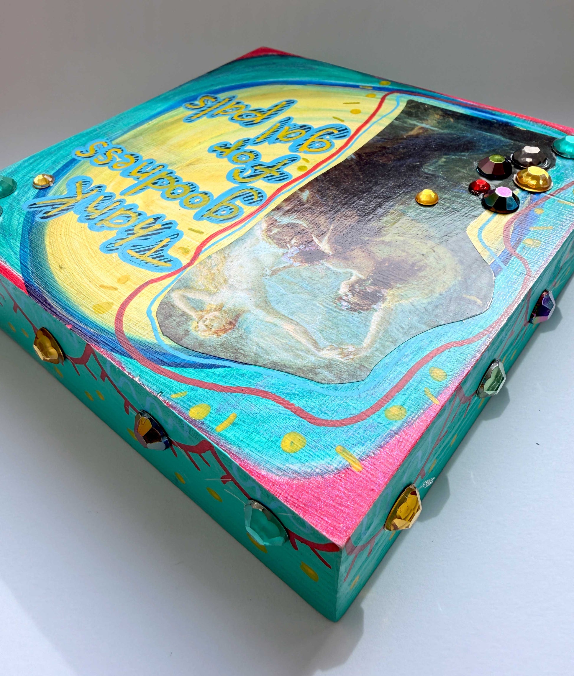Colorful box with artistic design and embedded stones on a white background