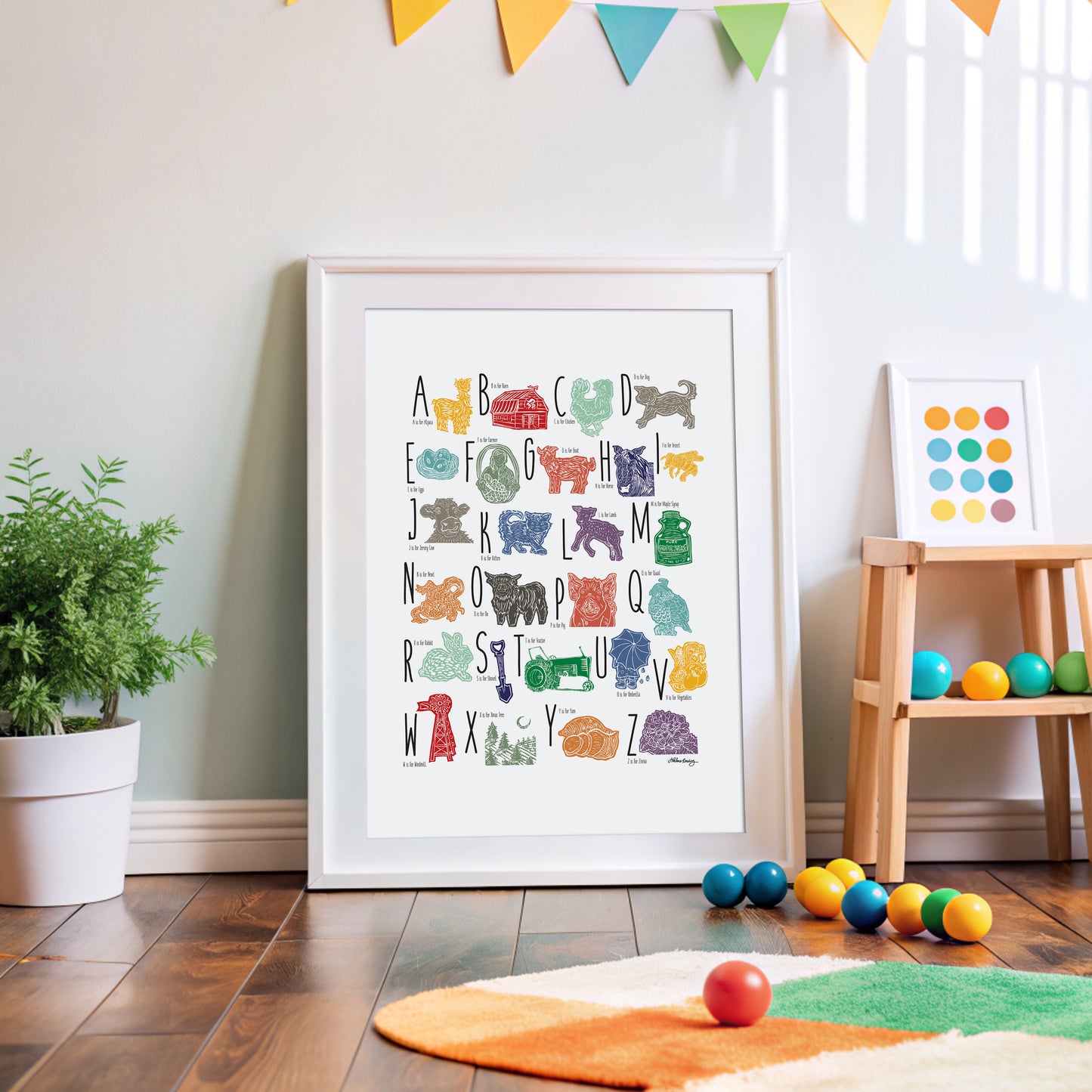 A colorful woodblock print alphabet poster featuring illustrations of farm animals, displayed on a white wall.