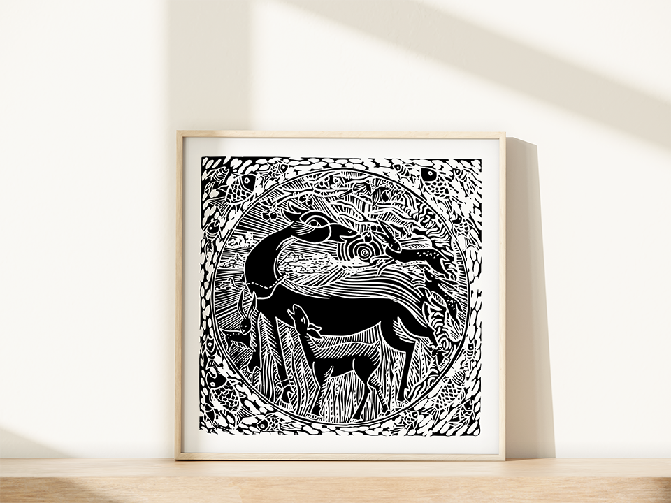 Framed black and white artwork of two deer in a natural setting on a white wall.