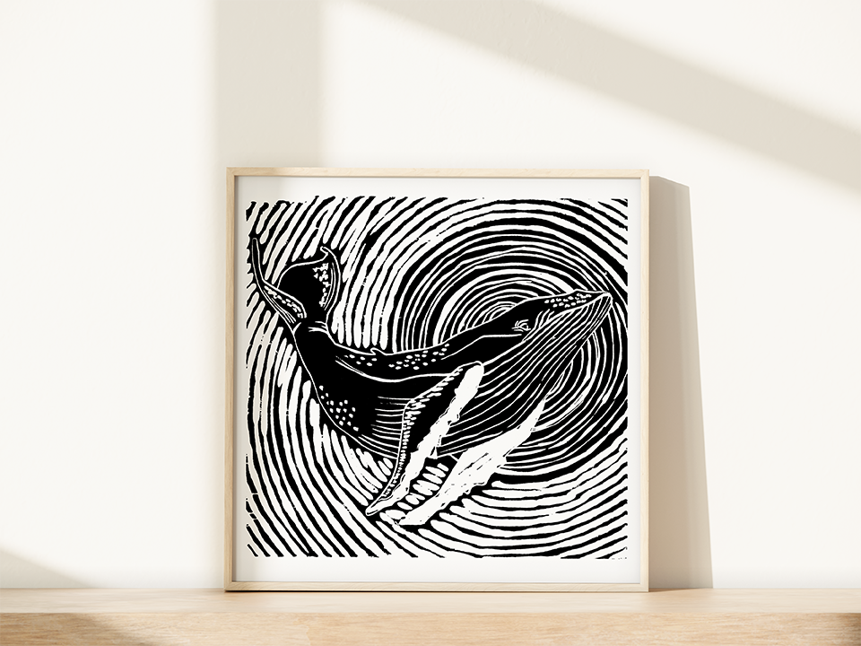 Framed black and white artwork of a stylized whale with concentric circles on a white wall.