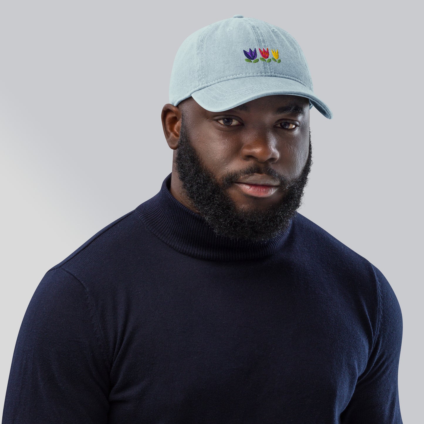Tulip design on denim hat worn by man with a beard