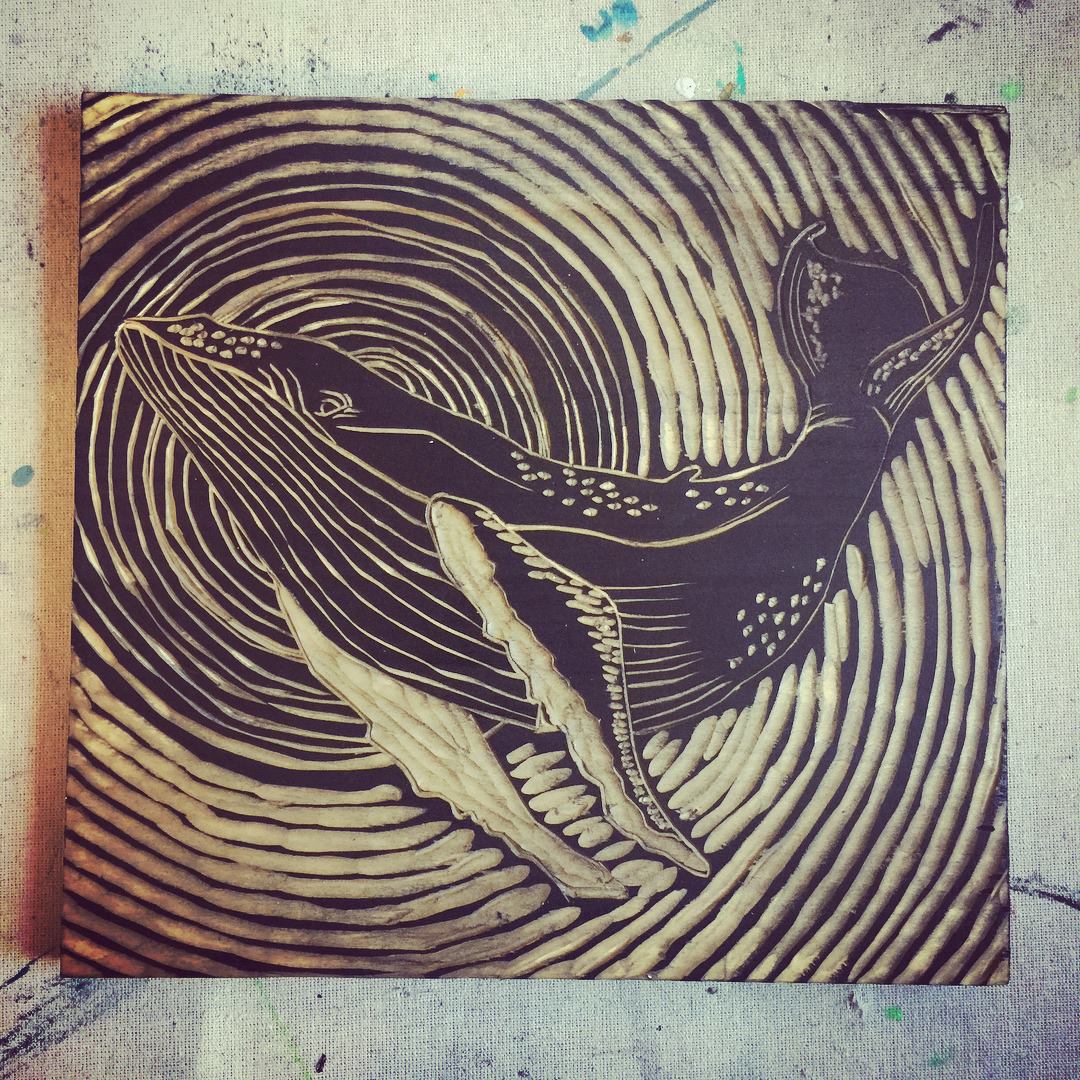 Woodcut-style illustration of a whale with wavy lines on a textured surface