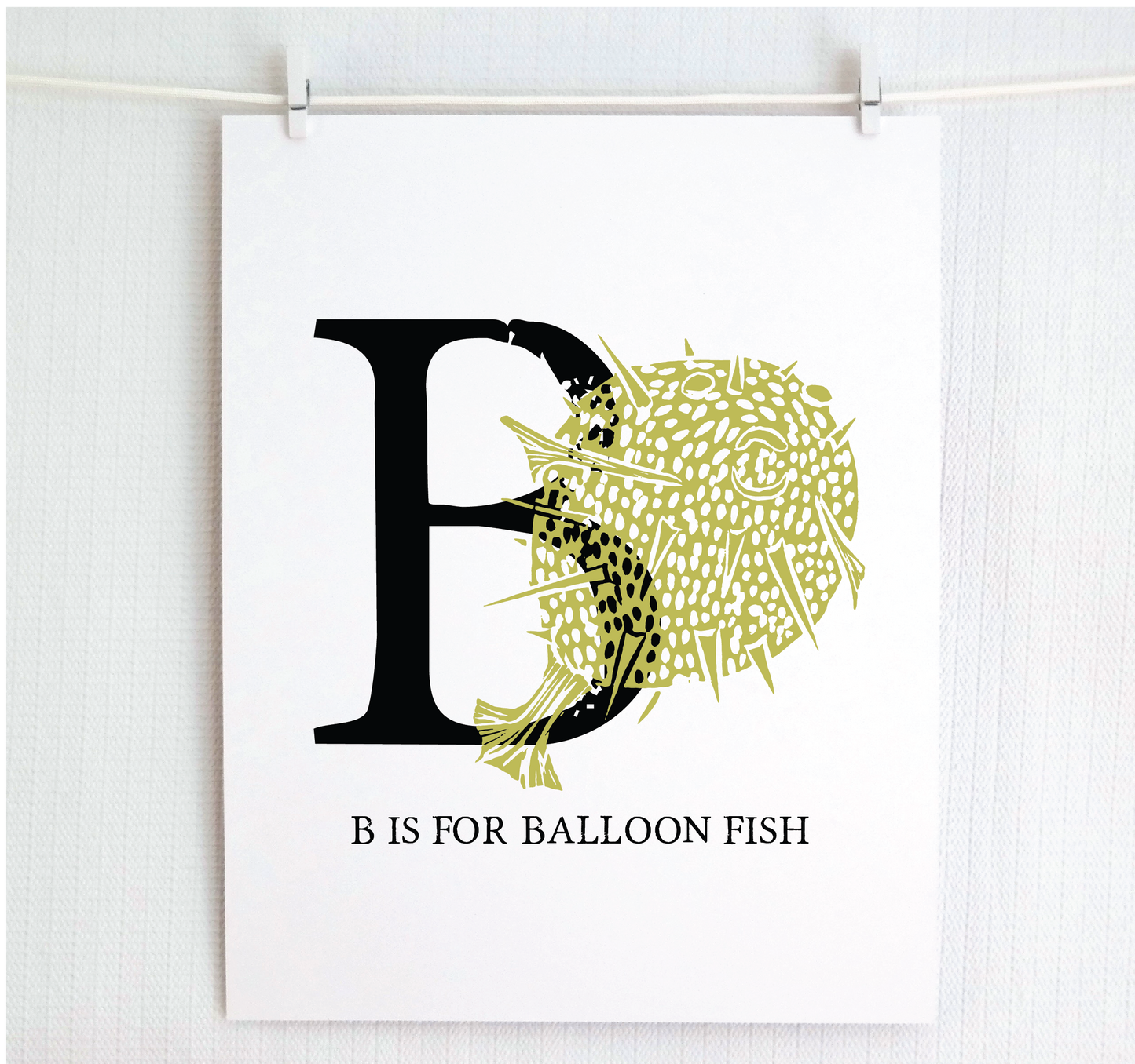 An illustrated balloon fish with done in printmaking style over decorative style block lettering text “B” with “B is for Balloon Fish” text printed below.
