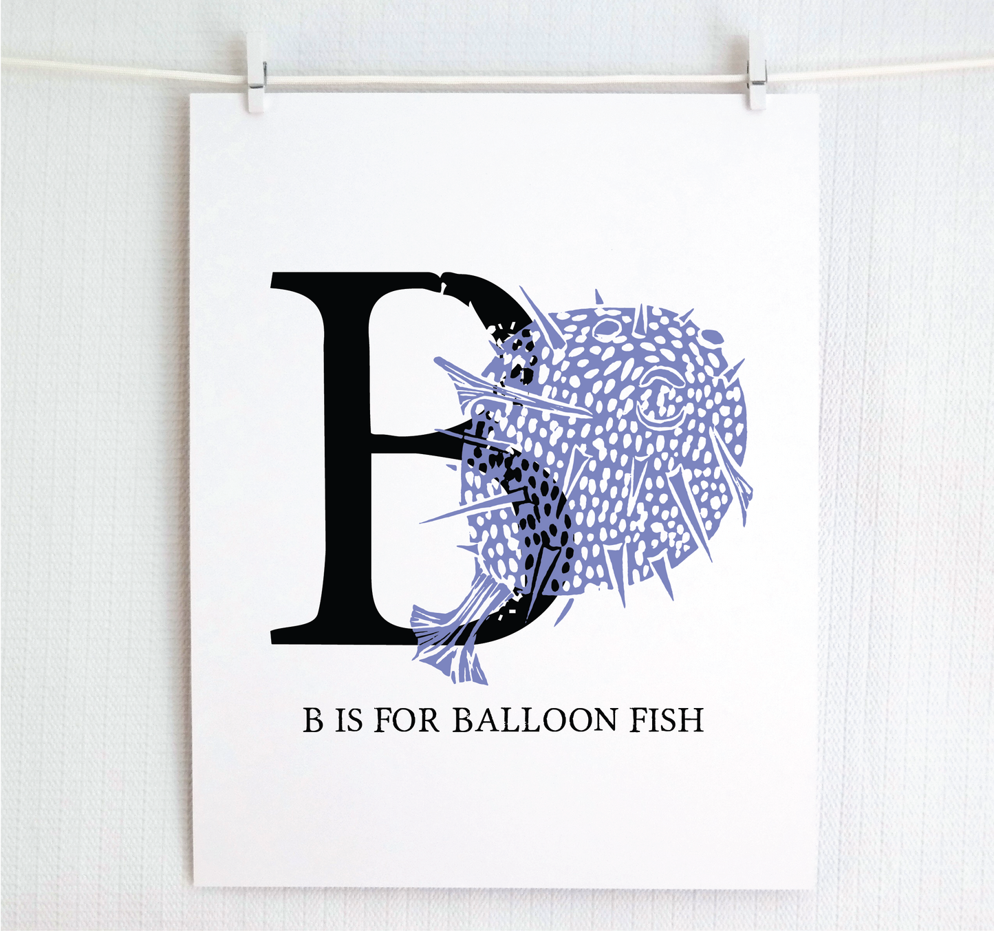 An illustrated balloon fish with done in printmaking style over decorative style block lettering text “B” with “B is for Balloon Fish” text printed below.
