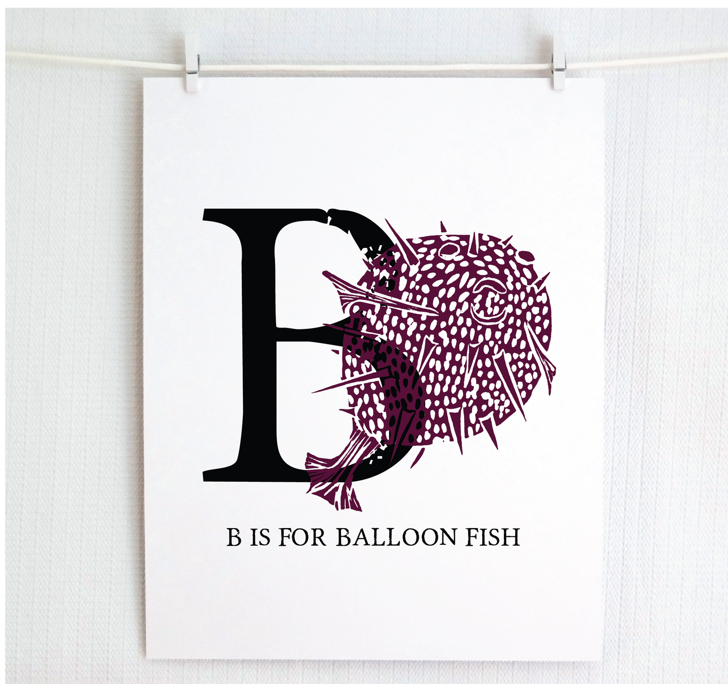 An illustrated balloon fish with done in printmaking style over decorative style block lettering text “B” with “B is for Balloon Fish” text printed below.
