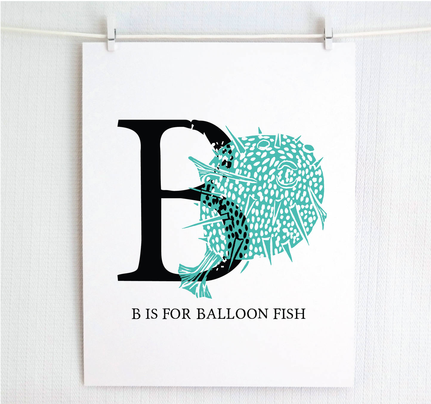 An illustrated balloon fish with done in printmaking style over decorative style block lettering text “B” with “B is for Balloon Fish” text printed below.
