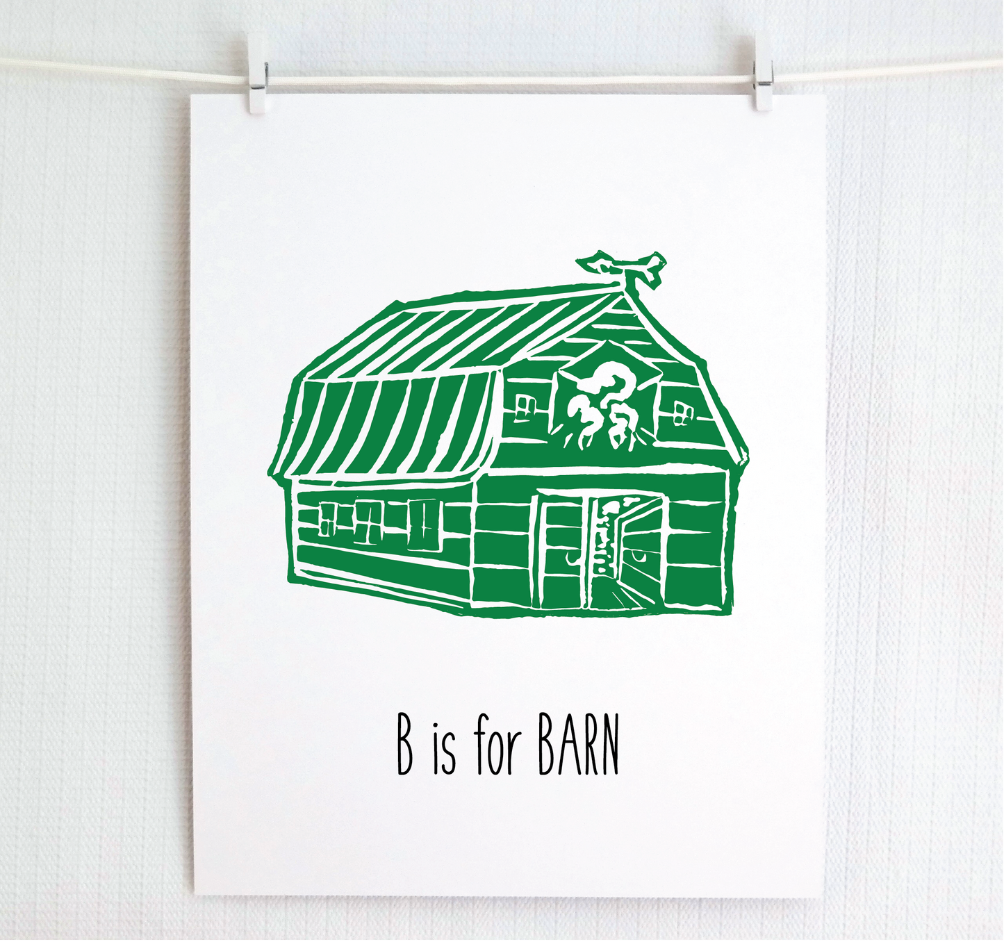 An illustrated barn with stands with an open door and arrow weathervane over hand written style, thin block lettering text that says “B for Barn.”
