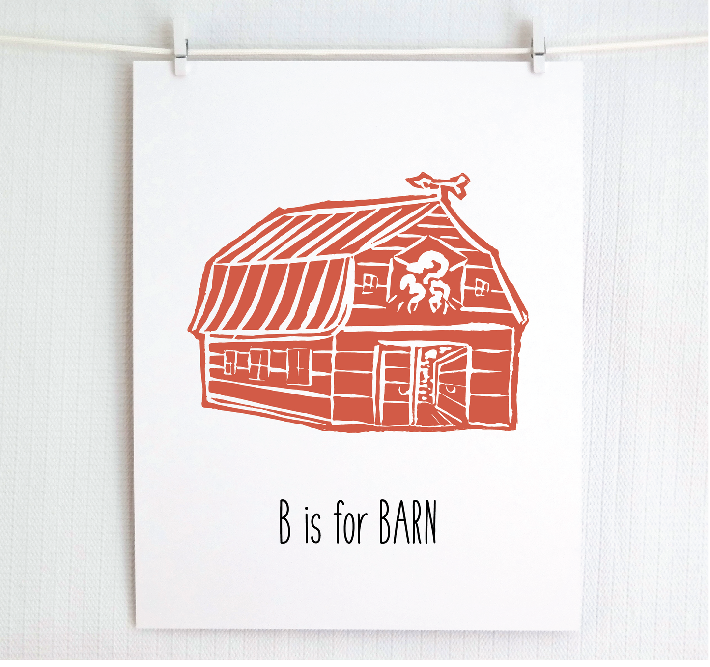 An illustrated barn with stands with an open door and arrow weathervane over hand written style, thin block lettering text that says “B for Barn.”
