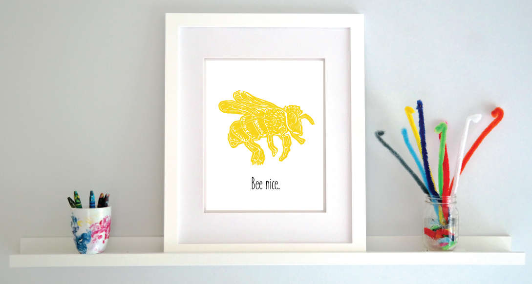 An illustrated bee with textured wings and body hovers over hand written style block lettering text that says “Bee nice.”
