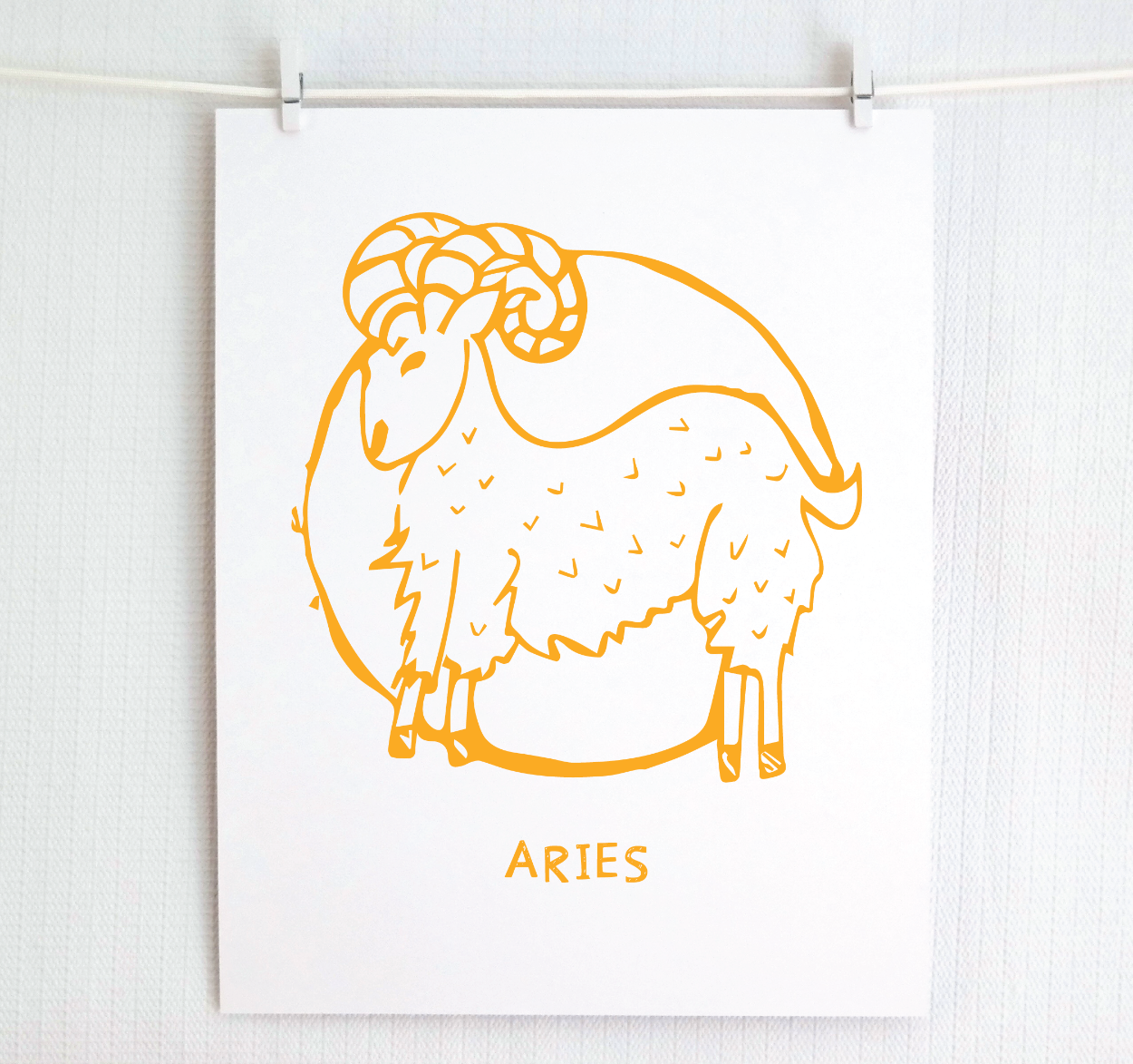 An illustration of the ARIES Zodiac sign as a ram, printed on paper with the word ‘ARIES’ at the bottom in gold.