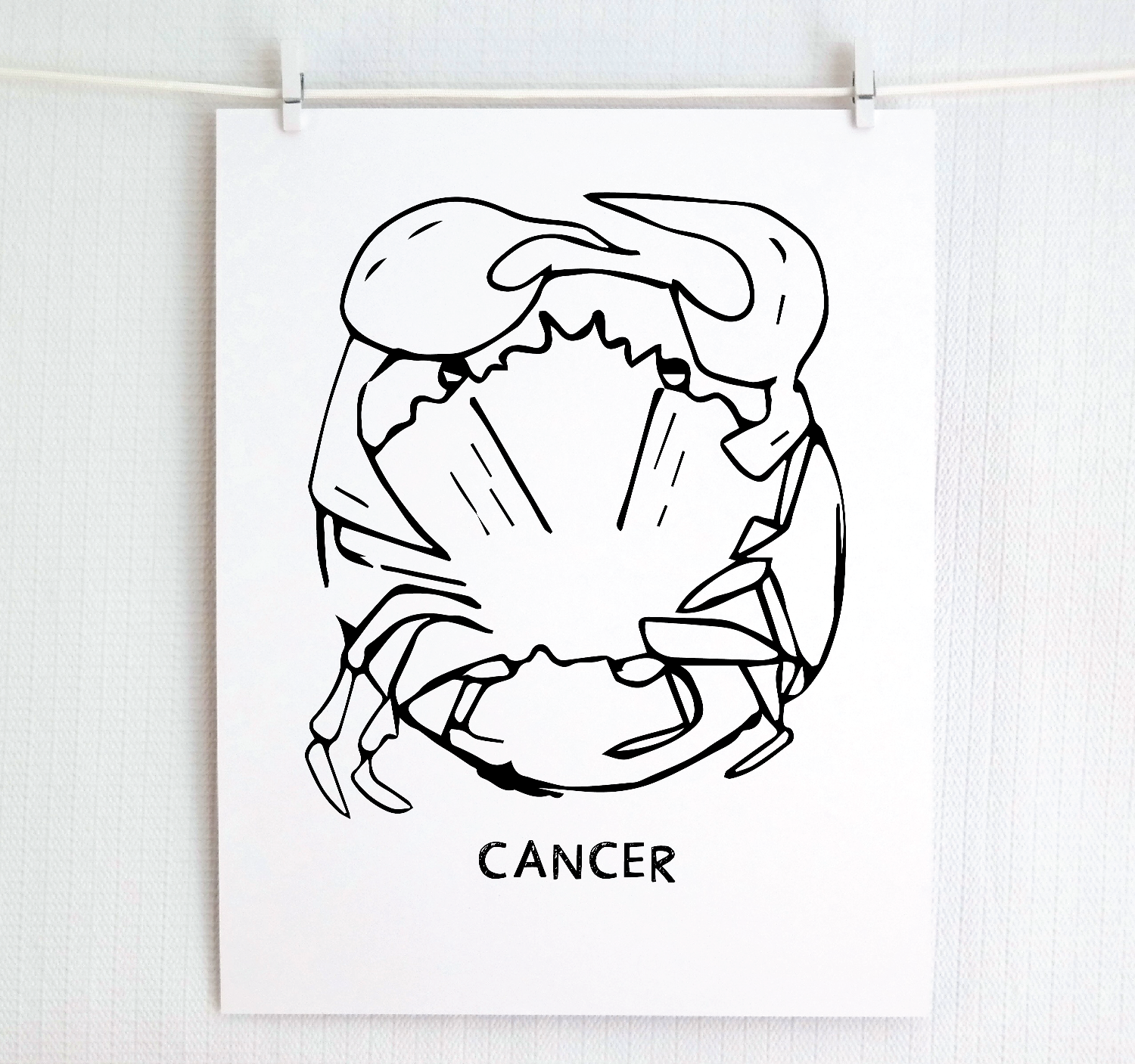 An illustration of the CANCER Zodiac sign as a crab, printed on paper with the word ‘CANCER’ at the bottom.