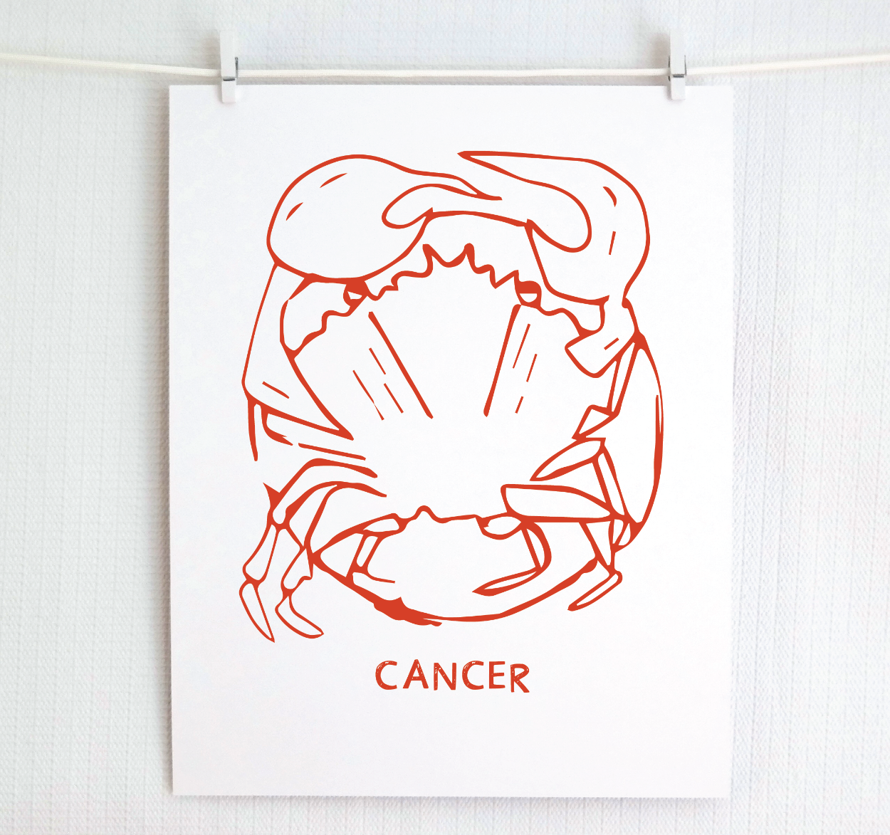 An illustration of the CANCER Zodiac sign as a crab, printed on paper with the word ‘CANCER’ at the bottom in red.