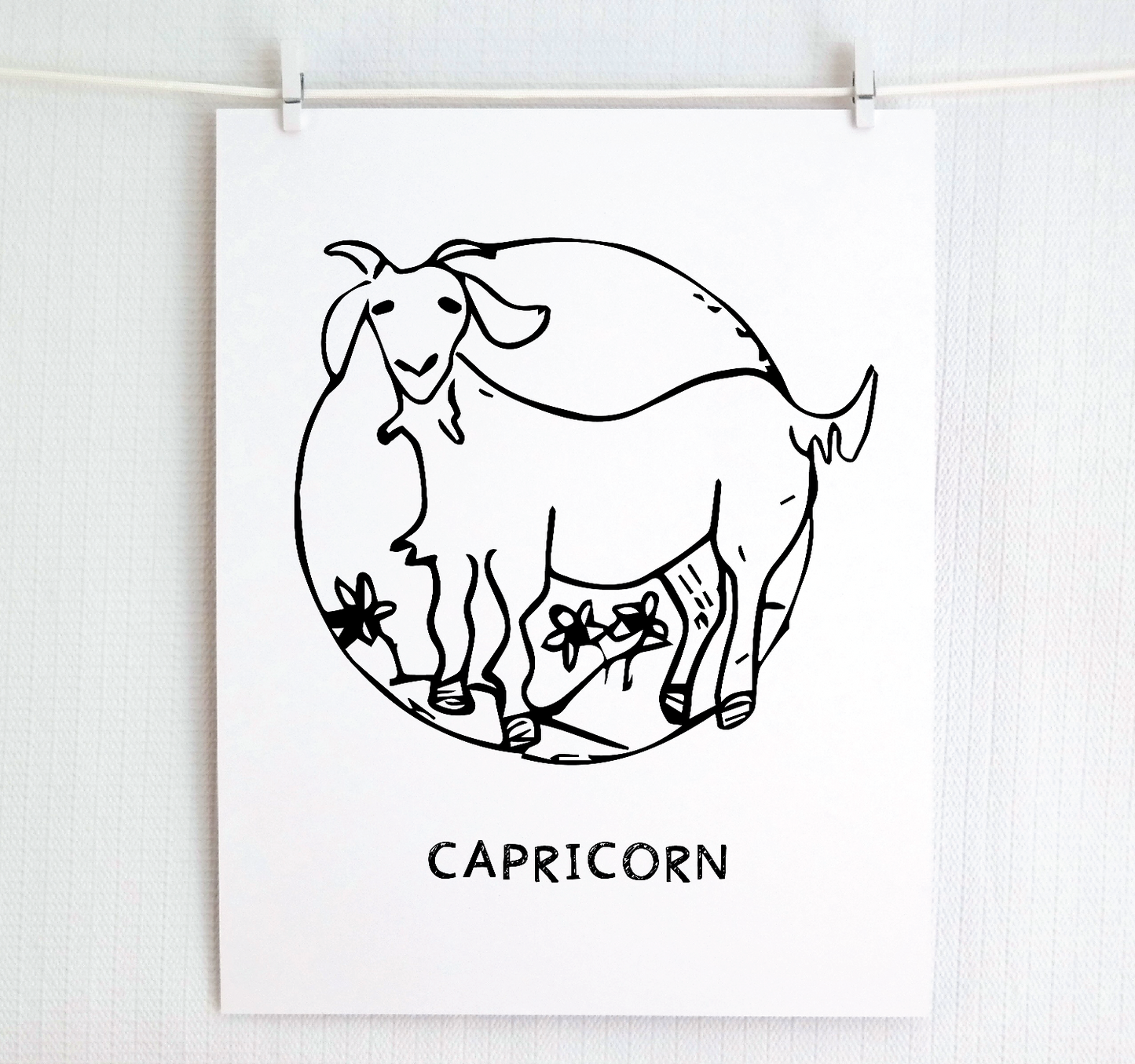 An illustration of the CAPRICORN Zodiac sign as a goat, printed on paper with the word ‘CAPRICORN’ at the bottom.