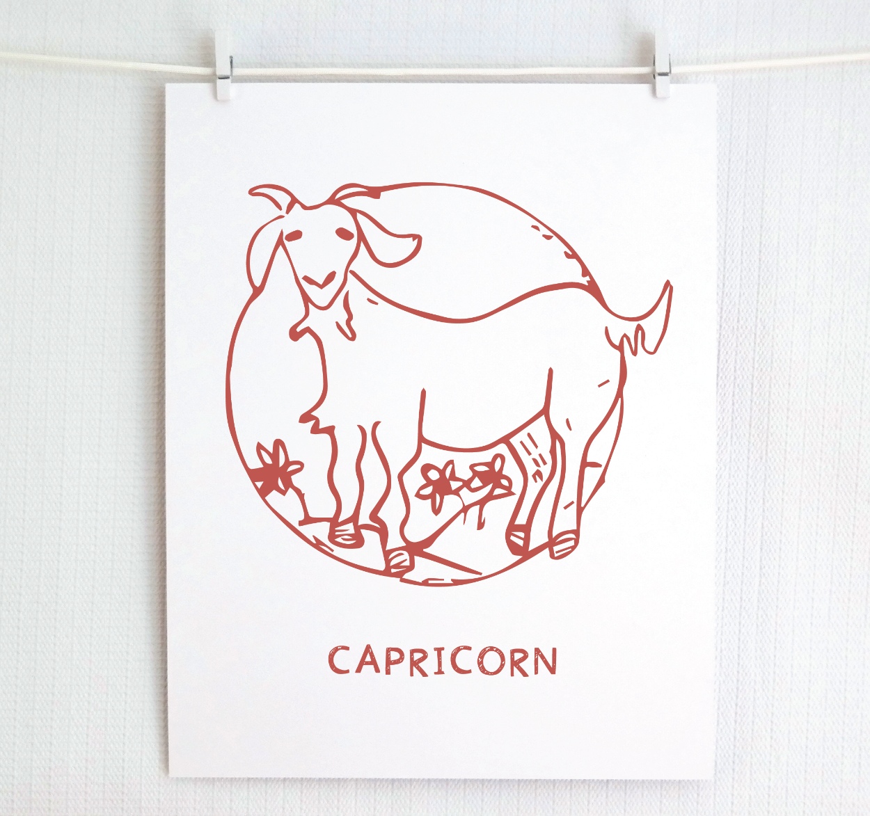 An illustration of the CAPRICORN Zodiac sign as a goat, printed on paper with the word ‘CAPRICORN’ at the bottom in blush.