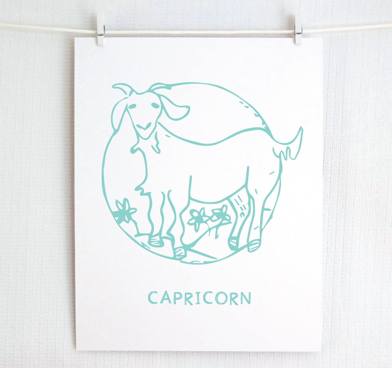 An illustration of the CAPRICORN Zodiac sign as a goat, printed on paper with the word ‘CAPRICORN’ at the bottom in teal.