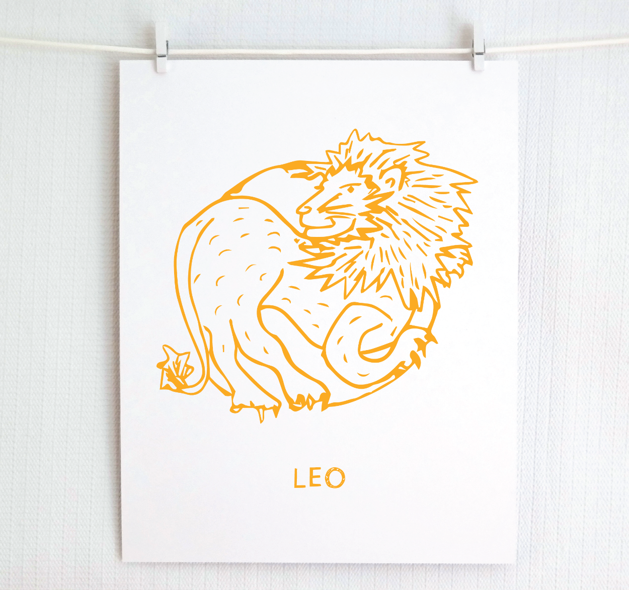 An illustration of the LEO Zodiac sign as a lion, printed on paper with the word ‘LEO’ at the bottom in gold.