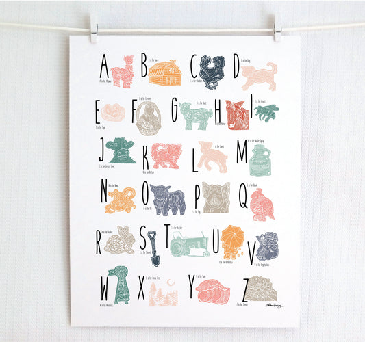 A colorful woodblock print alphabet poster featuring illustrations of farm animals, displayed on a white wall.