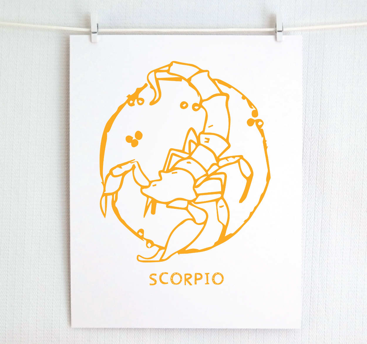 An illustration of the SCORPIO Zodiac sign as a scorpion, printed on paper with the word ‘SCORPIO’ at the bottom in gold.