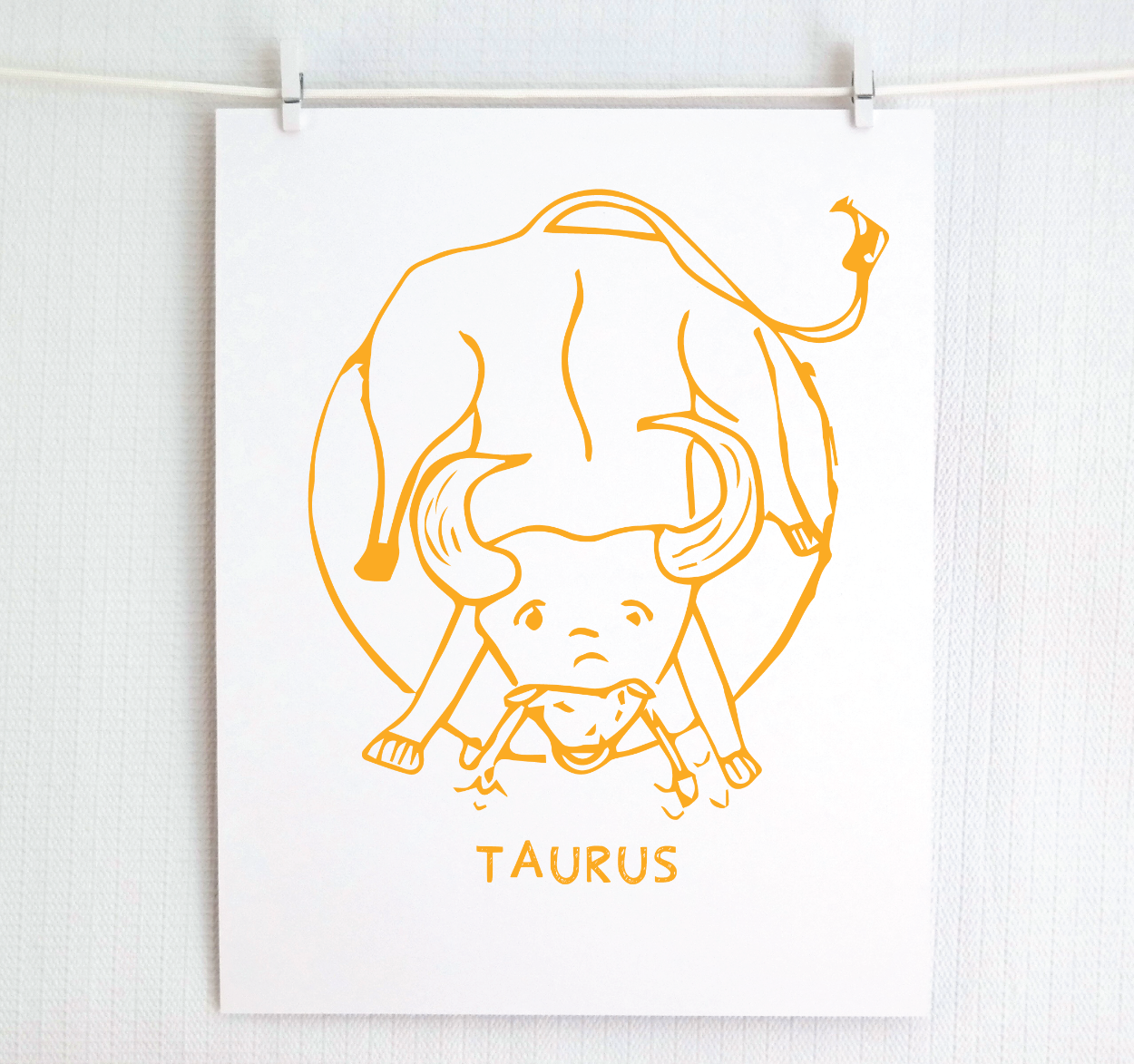 An illustration of the TAURUS Zodiac sign as a bull, printed on paper with the word ‘TAURUS’ at the bottom in gold.