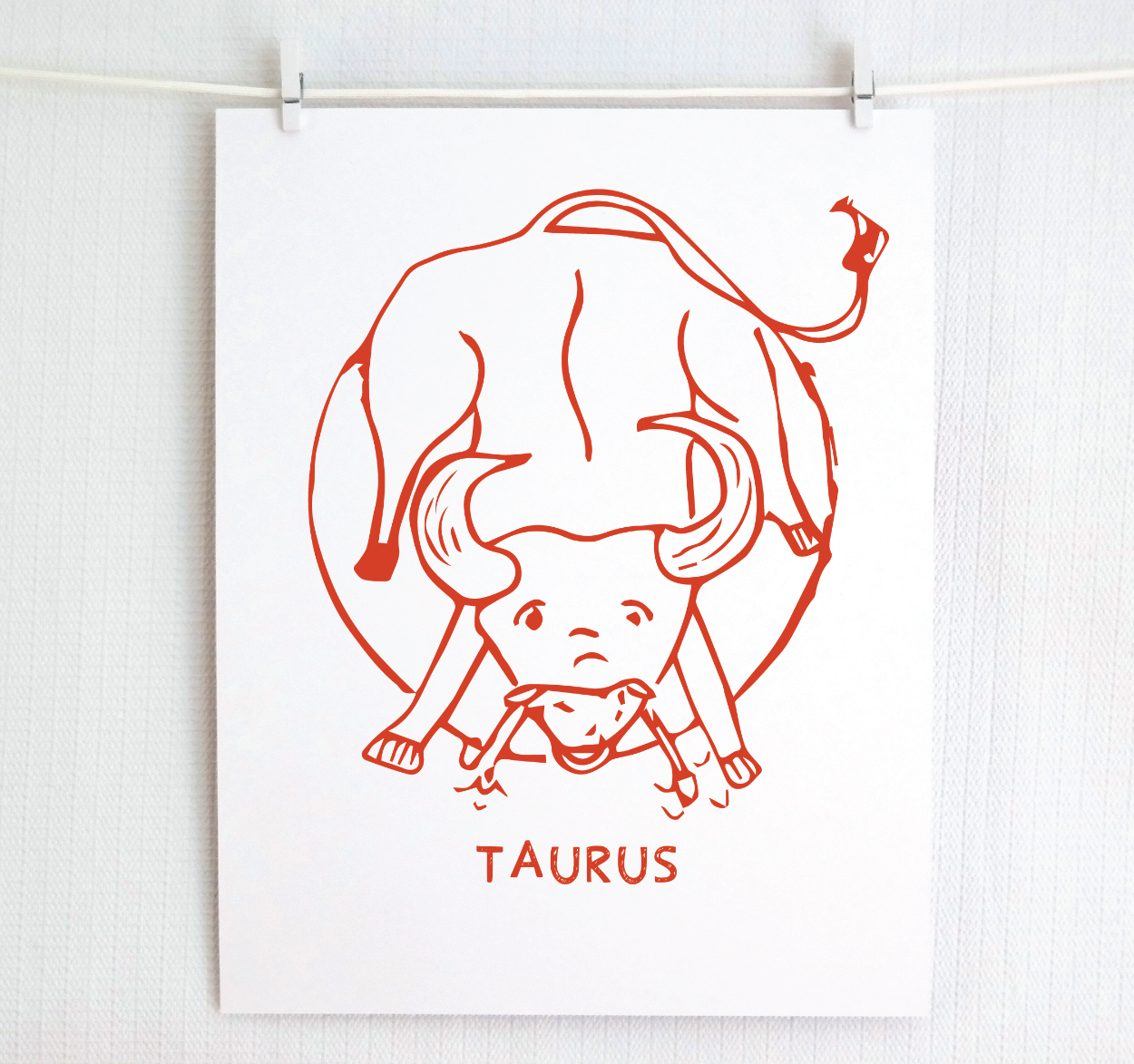 An illustration of the TAURUS Zodiac sign as a bull, printed on paper with the word ‘TAURUS’ at the bottom in red.