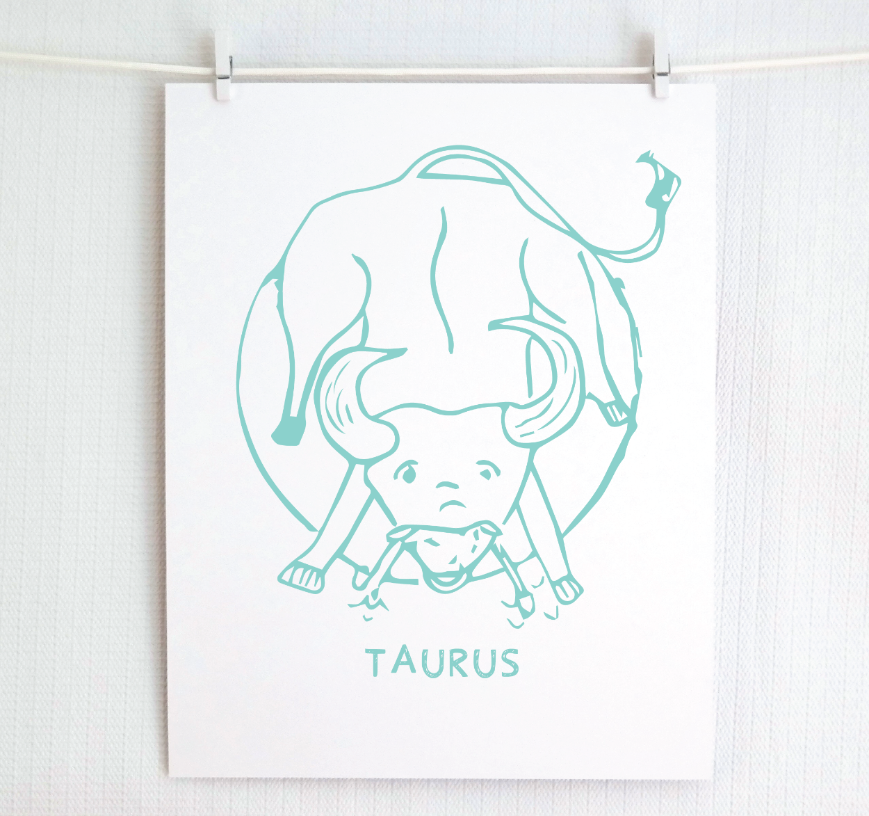 An illustration of the TAURUS Zodiac sign as a bull, printed on paper with the word ‘TAURUS’ at the bottom in teal.