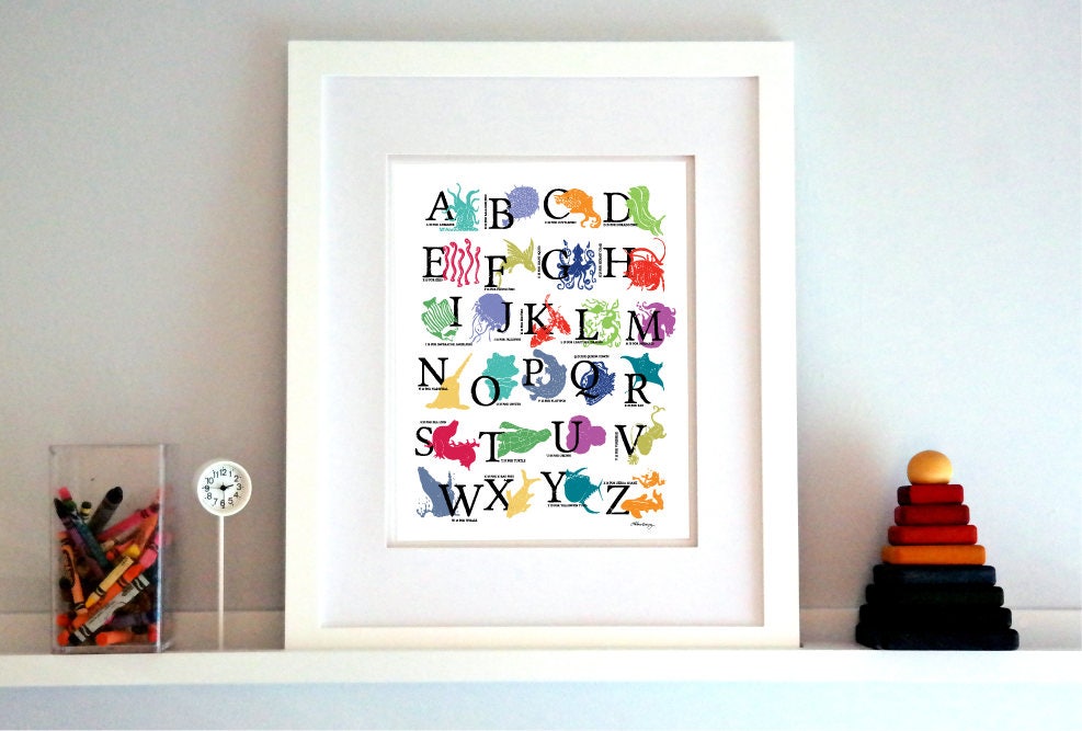 A colorful woodblock print alphabet poster featuring various underwater creatures illustrated alongside each letter.