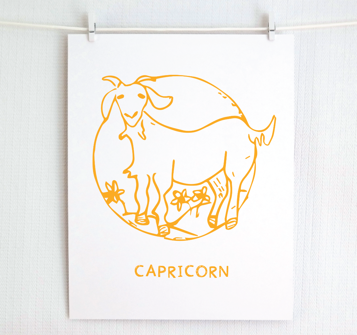 An illustration of the CAPRICORN Zodiac sign as a goat, printed on paper with the word ‘CAPRICORN’ at the bottom in gold.