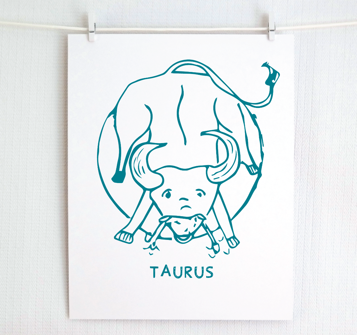 An illustration of the TAURUS Zodiac sign as a bull, printed on paper with the word ‘TAURUS’ at the bottom in dark teal.
